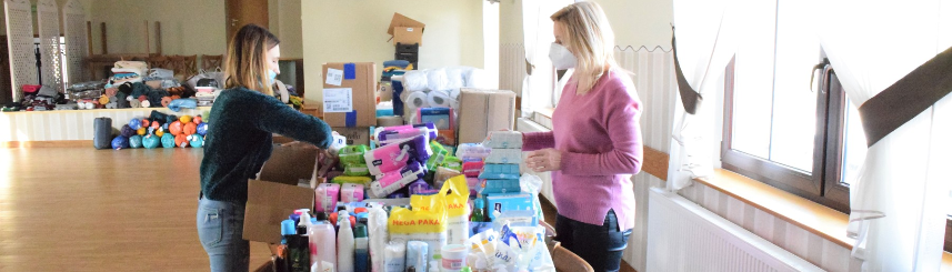Dwie kobiety segregują dary - artykuły chemiczne, przekazane przez mieszkańców